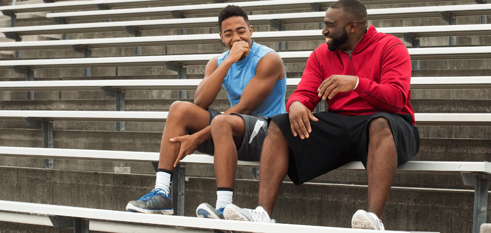 athlete and son on bleacher